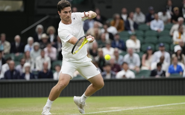 Miomir Kecmanovic of Serbia plays a forehand return to Jannik Sinner of Italy during their third round match at the Wimbledon tennis championships in London, Friday, July 5, 2024. (AP Photo/Alberto Pezzali)
