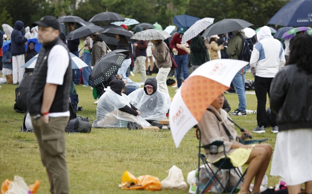 LONDON, ENGLAND - JULY 06: Spectators queue under umbrellas during day six of The Championships Wimbledon 2024 at All England Lawn Tennis and Croquet Club on July 06, 2024 in London, England. (Photo by Adam Pretty/Getty Images)