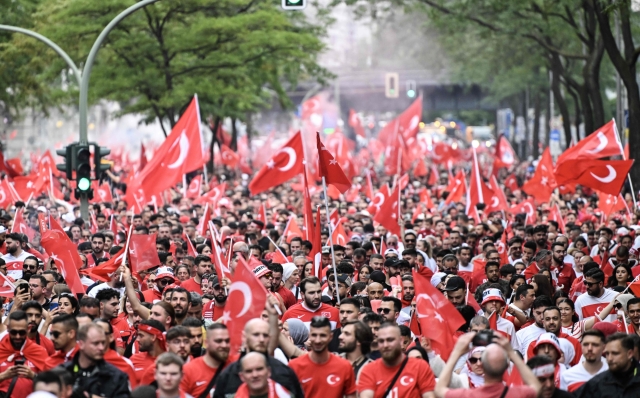 Hundreds of Turkey supporters crowdthe street cheer and with flags near Breitscheidplatz square in the center of Berlin before the quarter final UEFA Euro 2024 football match Netherlands v Turkey, held later at Berlin's Olympic stadium on June 6, 2024. (Photo by RALF HIRSCHBERGER / AFP)