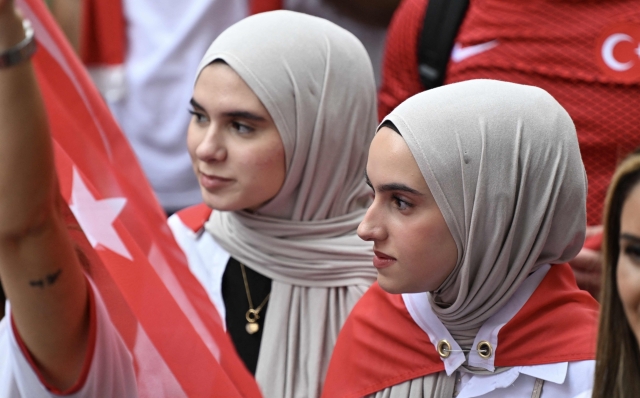 Women supporting Turkey wear scarves in their team's colours at Breitscheidplatz square in the center of Berlin before the quarter final UEFA Euro 2024 football match Netherlands v Turkey, held later at Berlin's Olympic stadium on June 6, 2024. (Photo by RALF HIRSCHBERGER / AFP)