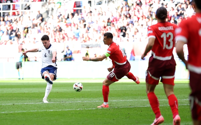 DUSSELDORF, GERMANY - JULY 06: Declan Rice of England shoots whilst under pressure from Granit Xhaka of Switzerland during the UEFA EURO 2024 quarter-final match between England and Switzerland at Düsseldorf Arena on July 06, 2024 in Dusseldorf, Germany. (Photo by Carl Recine/Getty Images)