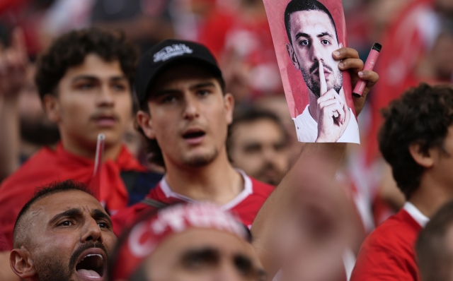 A fan holds a picture of Turkey's Merih Demiral before a quarterfinal match between the Netherlands and Turkey at the Euro 2024 soccer tournament in Berlin, Germany, Saturday, July 6, 2024. UEFA has suspended Turkey player Merih Demiral for two matches for making a controversial gesture at the European Championship. (AP Photo/Ariel Schalit)