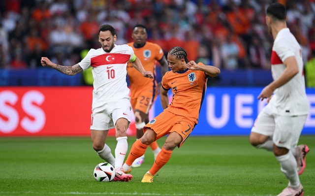 BERLIN, GERMANY - JULY 06: Xavi Simons of the Netherlands is challenged by Hakan Calhanoglu of Turkiye during the UEFA EURO 2024 quarter-final match between Netherlands and Türkiye at Olympiastadion on July 06, 2024 in Berlin, Germany. (Photo by Stu Forster/Getty Images)