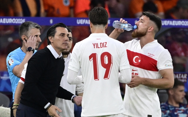 Turkey's Italian head coach Vincenzo Montella speaks with his players from the sidelines during the UEFA Euro 2024 quarter-final football match between the Netherlands and Turkey at the Olympiastadion in Berlin on July 6, 2024. (Photo by JOHN MACDOUGALL / AFP)