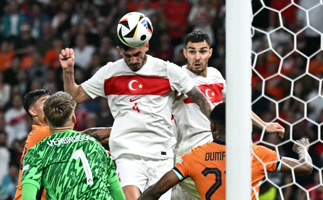 Turkey's defender #04 Samet Akaydin (C)  heads the ball and scores the opening goal during the UEFA Euro 2024 quarter-final football match between the Netherlands and Turkey at the Olympiastadion in Berlin on July 6, 2024. (Photo by JAVIER SORIANO / AFP)