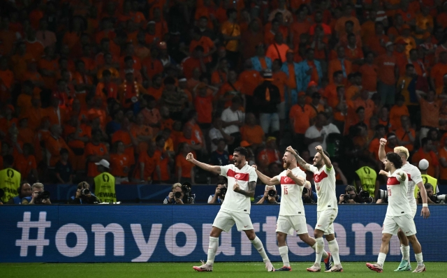 Turkey's defender #04 Samet Akaydin celebrates with teammates after scoring their first goal during the UEFA Euro 2024 quarter-final football match between the Netherlands and Turkey at the Olympiastadion in Berlin on July 6, 2024. (Photo by Angelos Tzortzinis / AFP)