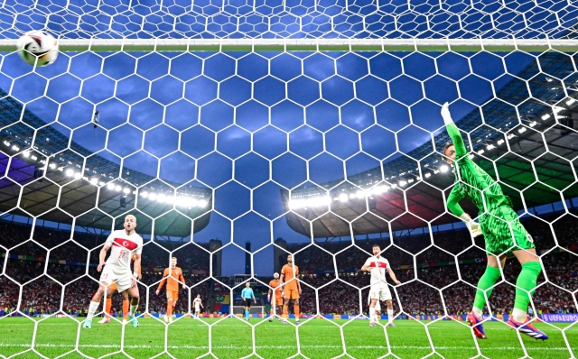 Netherlands' goalkeeper #01 Bart Verbruggen (R) concedes a goal scored by Turkey's defender #04 Samet Akaydin (unseen) during the UEFA Euro 2024 quarter-final football match between the Netherlands and Turkey at the Olympiastadion in Berlin on July 6, 2024. (Photo by JOHN MACDOUGALL / AFP)