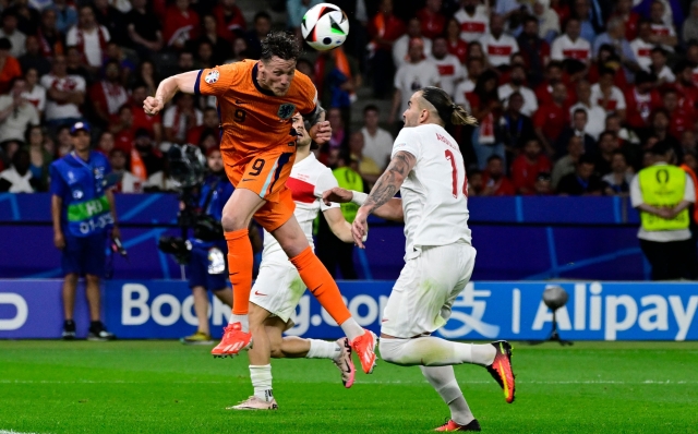 Netherlands' forward #09 Wout Weghorst heads the ball past Turkey's defender #14 Abdulkerim Bardakci during the UEFA Euro 2024 quarter-final football match between the Netherlands and Turkey at the Olympiastadion in Berlin on July 6, 2024. (Photo by JOHN MACDOUGALL / AFP)