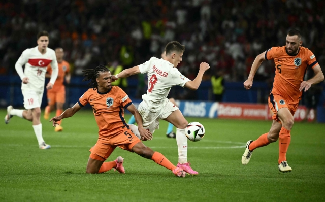 Netherlands' defender #05 Nathan Ake fouls Turkey's forward #08 Arda Guler during the UEFA Euro 2024 quarter-final football match between the Netherlands and Turkey at the Olympiastadion in Berlin on July 6, 2024. (Photo by Angelos Tzortzinis / AFP)