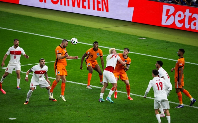 Netherlands' defender #06 Stefan de Vrij (3L) heads the ball and scores his team's first goal during the UEFA Euro 2024 quarter-final football match between the Netherlands and Turkey at the Olympiastadion Berlin in Berlin on July 6, 2024. (Photo by Ronny HARTMANN / AFP)