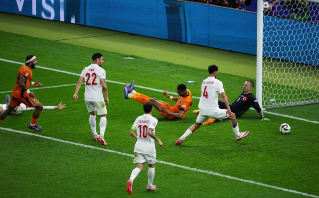 Turkey's defender #18 Mert Muldur (L) scores an own-goal during the UEFA Euro 2024 quarter-final football match between the Netherlands and Turkey at the Olympiastadion Berlin in Berlin on July 6, 2024. (Photo by Ronny HARTMANN / AFP)