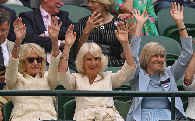 Britain's Queen Camilla (C) takes part in a Mexican Wave to cheer on US player Taylor Fritz and Italy's Lorenzo Musetti during their men's singles quarter-finals tennis match on the tenth day of the 2024 Wimbledon Championships at The All England Lawn Tennis and Croquet Club in Wimbledon, southwest London, on July 10, 2024. (Photo by ANDREJ ISAKOVIC / AFP) / RESTRICTED TO EDITORIAL USE