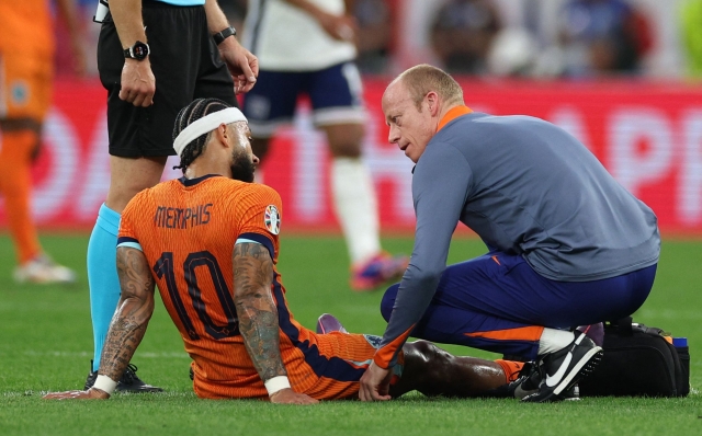 Netherlands' forward #10 Memphis Depay (l) reacts on the ground   during the UEFA Euro 2024 semi-final football match between the Netherlands and England at the BVB Stadion in Dortmund on July 10, 2024. (Photo by Adrian DENNIS / AFP)