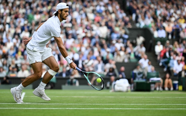Italy's Lorenzo Musetti returns against Serbia's Novak Djokovic during their men's singles semi-final tennis match on the twelfth day of the 2024 Wimbledon Championships at The All England Lawn Tennis and Croquet Club in Wimbledon, southwest London, on July 12, 2024. (Photo by ANDREJ ISAKOVIC / AFP) / RESTRICTED TO EDITORIAL USE