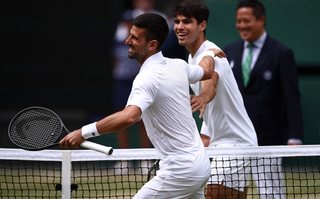 TOPSHOT - Serbia's Novak Djokovic (front) and Spain's Carlos Alcaraz (rear) returns against Spain's Carlos Alcaraz joke together prior to the start of their men's singles final tennis match on the fourteenth day of the 2024 Wimbledon Championships at The All England Lawn Tennis and Croquet Club in Wimbledon, southwest London, on July 14, 2024. (Photo by HENRY NICHOLLS / AFP) / RESTRICTED TO EDITORIAL USE