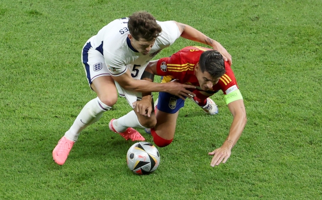 epa11478407 John Stones (L) of England in action against Alvaro Morata of Spain during the UEFA EURO 2024 final soccer match between Spain and England, in Berlin, Germany, 14 July 2024.  EPA/GEORGI LICOVSKI