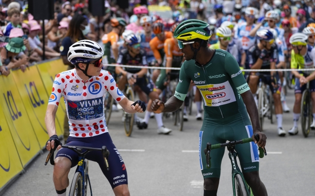 Denmark's Jonas Vingegaard, wearing the best climber's dotted jersey as the runner-up in the ranking, and Eritrea's Biniam Girmay, wearing the best sprinter's green jersey, pump fists prior to the start of the nineteenth stage of the Tour de France cycling race over 144.6 kilometers (89.9 miles) with start in Embrun and finish in Isola 2000, France, Friday, July 19, 2024. (AP Photo/Jerome Delay)