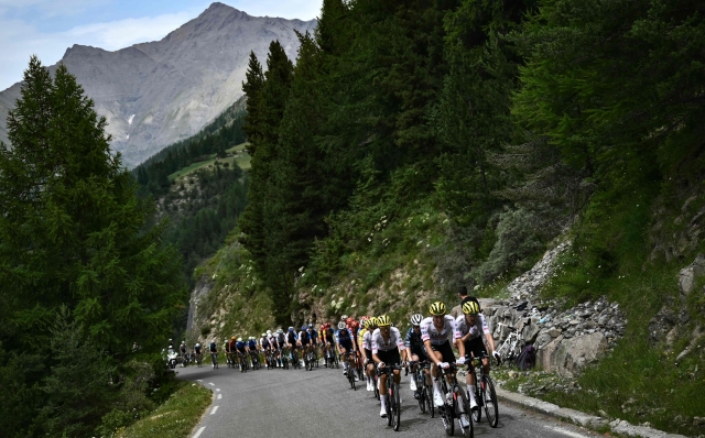 UAE Team Emirates team's German rider Nils Politt leads the pack of riders (peloton) in the ascent of the Cime de la Bonette during the 19th stage of the 111th edition of the Tour de France cycling race, 144,6 km between Embrun and Isola 2000, in the French Alps, on July 19, 2024. (Photo by Marco BERTORELLO / AFP)
