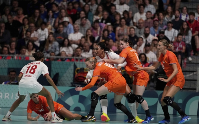 Angela Malestein, of the Netherlands, shields the ball against Chelsia Gabriel, of Angola, during the women's handball between Angola and Netherlands, at the 2024 Summer Olympics, Thursday, July 25, 2024, in Paris, France. (AP Photo/Brian Inganga)