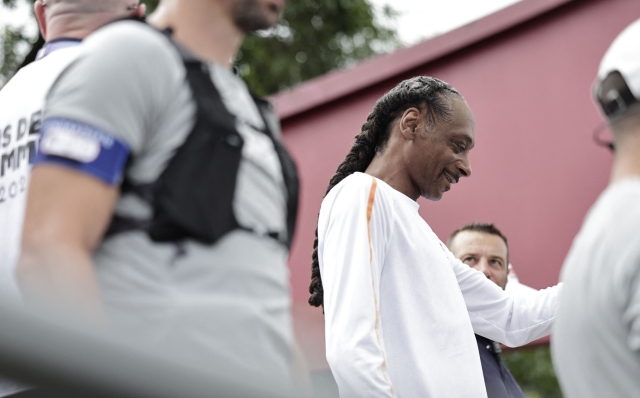 US rapper Snoop Dogg walks as part of the 2024 Paris Olympic Games Torch Relay, on the day of the opening ceremony, in Saint-Denis, outside Paris, on July 26, 2024. (Photo by STEPHANE DE SAKUTIN / AFP)