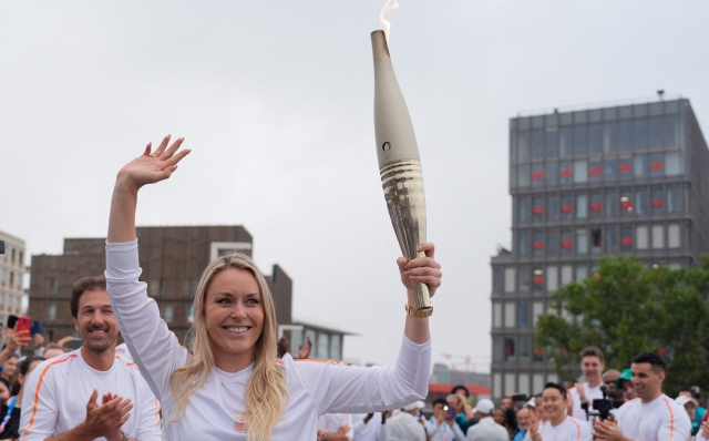 Former US skier Lindsey Vonn carries the Olympic torch in the Olympic Village in Paris on July 26, 2024, ahead of the Paris 2024 Olympic Games. (Photo by David Goldman / POOL / AFP)