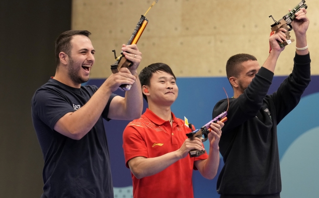 Gold medalist China\'s Xie Yu, center, celebrates with silver medalist Italy\'s Frederico Nilo Maldini, left, and bronze medalist taly\'s Paolo Monna after the 10m air pistol men\'s final at the 2024 Summer Olympics, Sunday, July 28, 2024, in Chateauroux, France. (AP Photo/Manish Swarup)    Associated Press / LaPresse Only italy and Spain