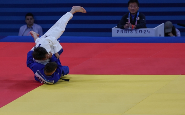 Italy's Matteo Piras and Serbia's Strahinja Buncic (Blue) compete in the judo men's -66kg round of 16 bout of the Paris 2024 Olympic Games at the Champ-de-Mars Arena, in Paris on July 28, 2024. (Photo by Jack GUEZ / AFP)