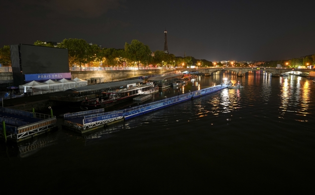 Technicians remove the pontoon for the start of the triathlon events after the event was postponed over concerns about water quality in Paris' Seine River, at the 2024 Summer Olympics, Tuesday, July 30, 2024, at the Pont Alexandre III bridge in Paris, France. (AP Photo/Vadim Ghirda)