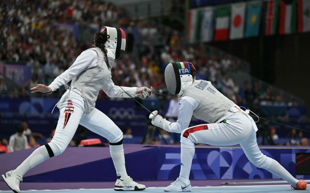 Egypt's Sara Amr Hossny (L) and Italy's Arianna Errigo compete in the women's foil team round of 8 bout during the Paris 2024 Olympic Games at the Grand Palais in Paris, on August 1, 2024. (Photo by Fabrice COFFRINI / AFP)