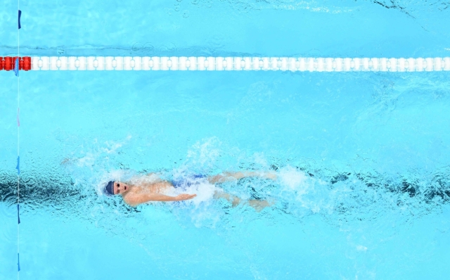 An overview shows (from top) Italy's Alberto Razzetti, France's Leon Marchand and Britain's Duncan Scott competing a heat of the men's 200m individual medley swimming event during the Paris 2024 Olympic Games at the Paris La Defense Arena in Nanterre, west of Paris, on August 1, 2024. (Photo by Manan VATSYAYANA / AFP)