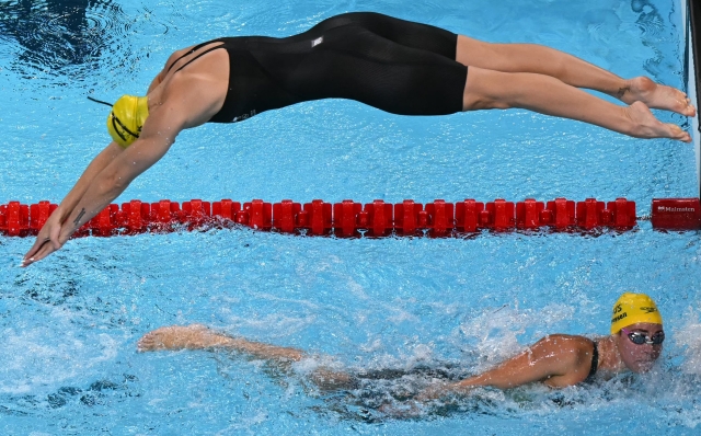 Australia's Shayna Jack (up) and Australia's Brianna Throssell compete in  a heat of the women's 4x200m freestyle relay swimming event during the Paris 2024 Olympic Games at the Paris La Defense Arena in Nanterre, west of Paris, on August 1, 2024. (Photo by Jonathan NACKSTRAND / AFP)