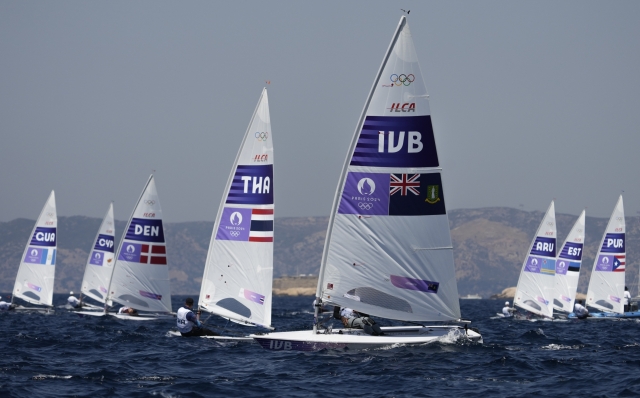 Thad Lettsome of the British Virgin Islands, foreground, competes in a men's dinghy race during the 2024 Summer Olympics, Thursday, Aug. 1, 2024, in Marseille, France. . (AP Photo/Carolyn Kaster)