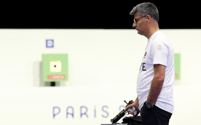 Turkey's Yusuf Dikec competes in the shooting 10m air pistol mixed team gold medal match during the Paris 2024 Olympic Games at Chateauroux Shooting Centre on July 30, 2024. (Photo by Alain JOCARD / AFP)