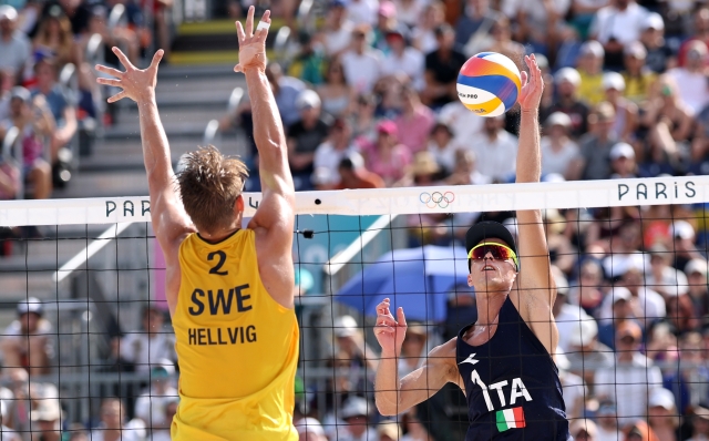 PARIS, FRANCE - AUGUST 01: Samuele Cottafava of Team Italy attacks the net against Jonatan Hellvig of Team Sweden during the Men's Preliminary Phase - Pool A match between Team Sweden and Team Italy on day six of the Olympic Games Paris 2024 at  on August 01, 2024 in Paris, France. (Photo by Lintao Zhang/Getty Images)