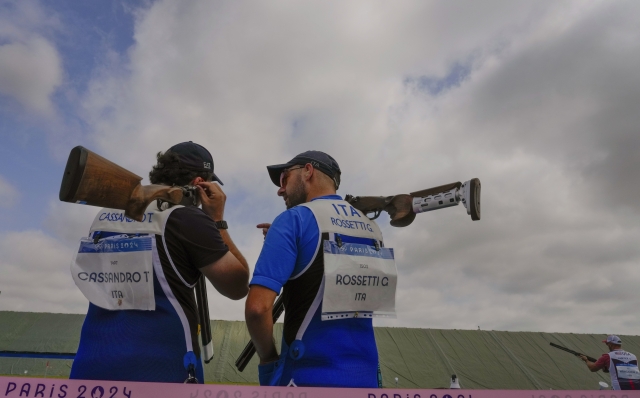 Italian athlete Tammaro Cassandro, left, talks to his teammate Gabriele Rossetti during the Skeet men pre-event training in Chateauroux, France, at the 2024 Summer Olympics, Thursday, Aug. 1, 2024. (AP Photo/Manish Swarup)