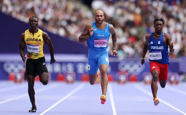 PARIS, FRANCE - AUGUST 03: (L-R) Abdul-Rasheed Saminu of Team Ghana, Lamont Marcell Jacobs of Team Italy and Davonte Howell of Team Cayman Islands compete on during the Men's 100m Round 1 on day eight of the Olympic Games Paris 2024 at Stade de France on August 03, 2024 in Paris, France. (Photo by Hannah Peters/Getty Images)