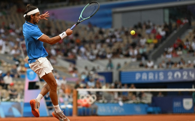 Italy's Lorenzo Musetti returns to Canada's Felix Auger-Aliassime during their men's singles bronze medal tennis match on Court Philippe-Chatrier at the Roland-Garros Stadium during the Paris 2024 Olympic Games, in Paris on August 3, 2024. (Photo by Miguel MEDINA / AFP)