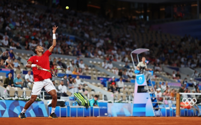 PARIS, FRANCE - AUGUST 03: Felix Auger-Aliassime of Team Canada serves during the Tennis Men's Singles Bronze medal match against Lorenzo Musetti of Team Italy on day eight of the Olympic Games Paris 2024 at Roland Garros on August 03, 2024 in Paris, France. (Photo by Clive Brunskill/Getty Images)