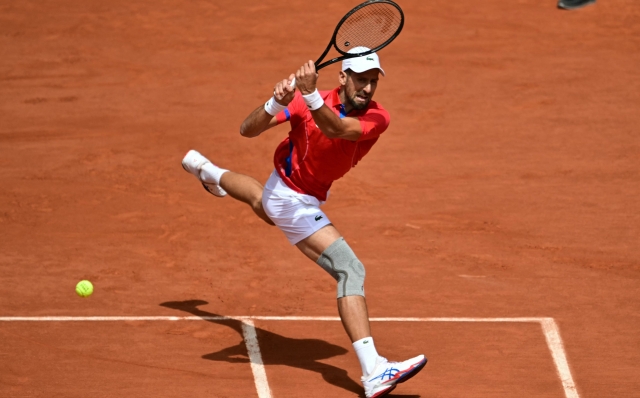 Serbia's Novak Djokovic returns to Spain's Carlos Alcaraz during their men's singles final tennis match on Court Philippe-Chatrier at the Roland-Garros Stadium during the Paris 2024 Olympic Games, in Paris on August 4, 2024. (Photo by Miguel MEDINA / AFP)