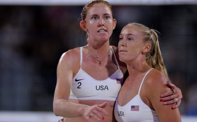 US' #02 Kelly Cheng (L) and US' #01 Sara Hughes celebrate a point in the women's round of 16 beach volleyball match between USA and Italy during the Paris 2024 Olympic Games at the Eiffel Tower Stadium in Paris on August 5, 2024. (Photo by Thomas SAMSON / AFP)