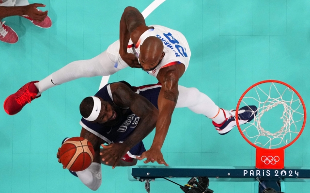 An overview shows USA's #06 LeBron James go to the basket past Puerto Rico's #28 Ismael Romero in the men's preliminary round group C basketball match between Puerto Rico and USA during the Paris 2024 Olympic Games at the Pierre-Mauroy stadium in Villeneuve-d'Ascq, northern France, on August 3, 2024. (Photo by Evelyn HOCKSTEIN / POOL / AFP)