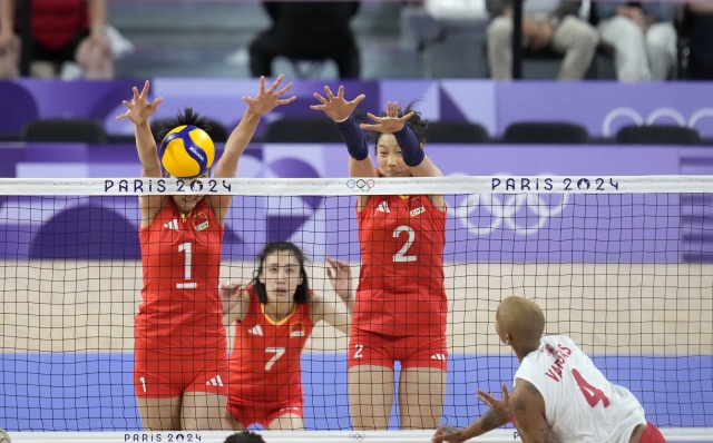 China's Yuan Xinyue , left, and Zhu Ting block a ball by Turkey's Melissa Vargas during a women's quarter final volleyball match between China and Turkey at the 2024 Summer Olympics, Tuesday, Aug. 6, 2024, in Paris, France. (AP Photo/Dolores Ochoa)