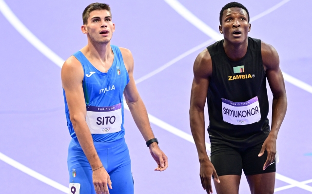 Italy's Luca Sito and Zambia's Muzala Samukonga react after competing in the men's 400m semi-final of the athletics event at the Paris 2024 Olympic Games at Stade de France in Saint-Denis, north of Paris, on August 6, 2024. (Photo by Martin  BERNETTI / AFP)