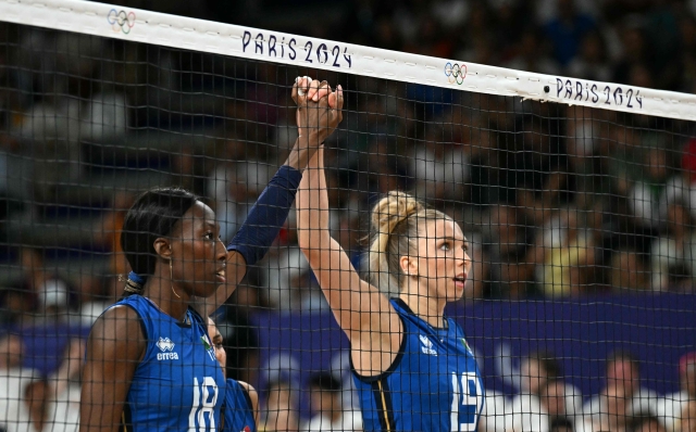 Italy's #18 Paola Ogechi Egonu (L) stands hand in hand with Italy's #19 Sarah Luisa Fahr prior to the volleyball women's quarter-final match between Italy and Serbia during the Paris 2024 Olympic Games at the South Paris Arena 1 in Paris on August 6, 2024. (Photo by PATRICIA DE MELO MOREIRA / AFP)