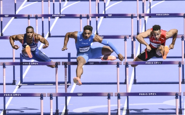 Italian Lorenzo Simonelli (C) in action during the qualifying race for the semi-finals of the 110 Obstacles at the Paris 2024 Olympic Games, in the Stade de France, 04 August 2024.   ANSA / CIRO FUSCO