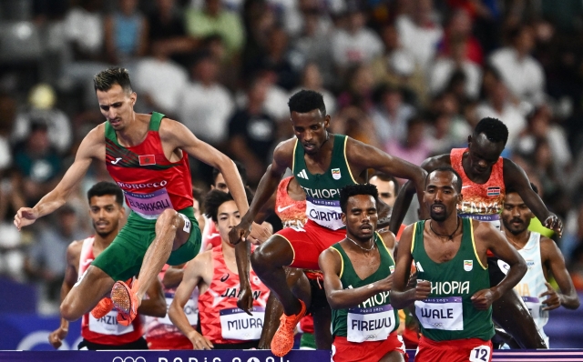 Ethiopia's Getnet Wale (R), Morocco's Soufiane El Bakkali (L) and other athletes compete in the men's 3000m steeplechase final of the athletics event at the Paris 2024 Olympic Games at Stade de France in Saint-Denis, north of Paris, on August 7, 2024. (Photo by Jewel SAMAD / AFP)