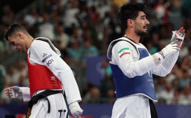 Iran's Mehran Barkhordari (R) celebrates after winning against Italy's Simone Alessio in the taekwondo men's -80kg quarter-final bout of the Paris 2024 Olympic Games at the Grand Palais in Paris on August 9, 2024. (Photo by David GRAY / AFP)