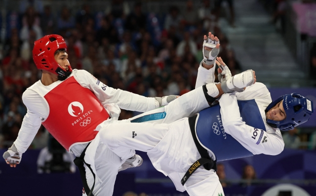 Uzbekistan's Jasurbek Jaysunov (L) competes against Italy's Simone Alessio in the taekwondo men's -80kg repechage bout of the Paris 2024 Olympic Games at the Grand Palais in Paris on August 9, 2024. (Photo by David GRAY / AFP)