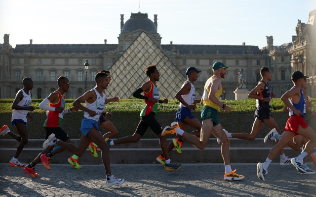 PARIS, FRANCE - AUGUST 10: Athletes run past the Musee du Louvre during the Men's Marathon during day fifteen of the Olympic Games Paris 2024 at Esplanade Des Invalides on August 10, 2024 in Paris, France. (Photo by Christian Petersen/Getty Images)