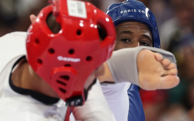 Refugee Olympic Team's Kasra Mehdipournejad (L) competes against Ivory Coast's Cheick Sallah Cisse in the taekwondo men's +80kg round of 16 bout of the Paris 2024 Olympic Games at the Grand Palais in Paris on August 10, 2024. (Photo by David GRAY / AFP)